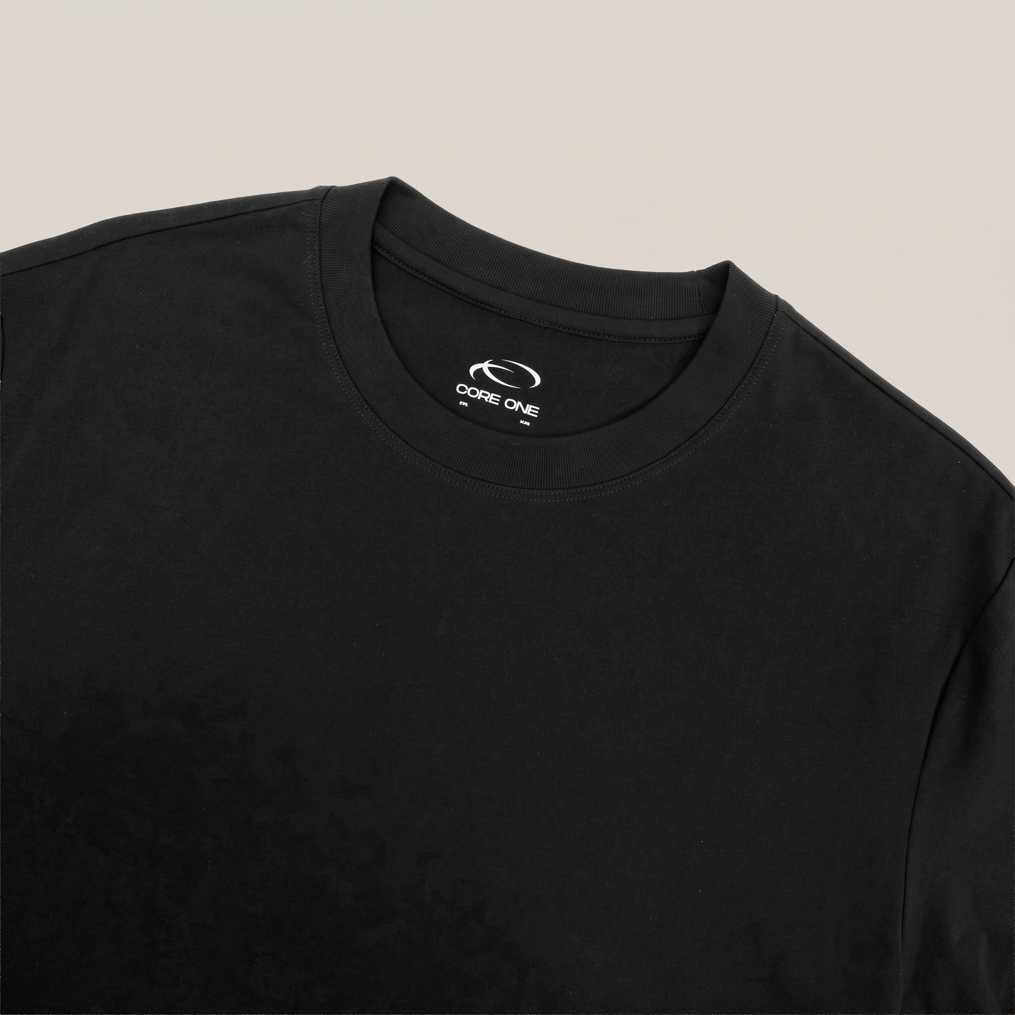Core One black tee close-up showing the flat collar and woven CORE ONE inner-neck label